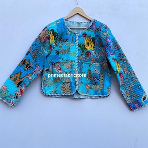 May include: A blue quilted jacket with a floral print and a striped lining. The jacket has a button closure and long sleeves.