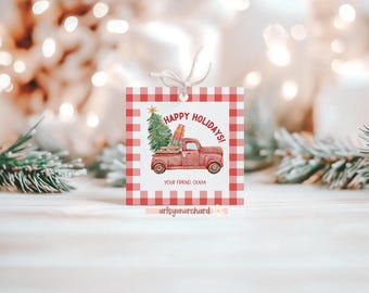 Puede incluir: Una etiqueta de regalo cuadrada con un borde de cuadros rojos y blancos. La etiqueta presenta una ilustración de acuarela de un camión rojo que transporta un árbol de Navidad y regalos, con el texto "HAPPY HOLIDAYS!" y "YOUR FRIEND, OLIVIA".