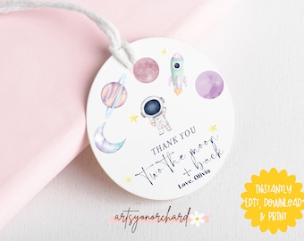 May include: Round white thank you tag with a watercolor illustration of planets, stars, a rocket, and an astronaut. The text reads "Thank you two the moon + back Love, Olivia" and "artsyonorchard".