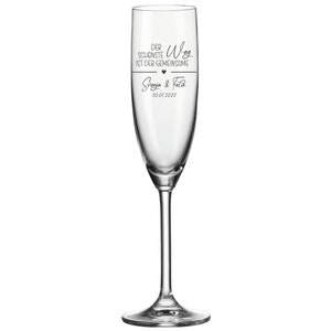 May include: A clear glass champagne flute with the text "Der sch&ouml;nste Weg ist der gemeinsame" and a heart symbol. Below the text is "Svenja & Felix" and the date "30.07.2022".