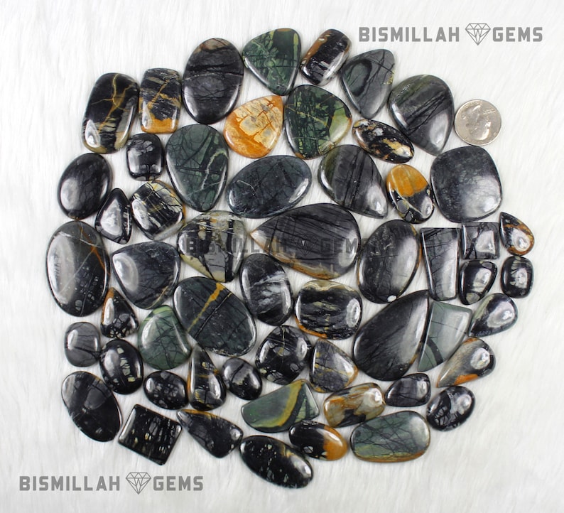 May include: A collection of 30 black, green, and yellow patterned stone cabochons. The stones are various shapes and sizes, and are arranged in a circle on a white background. BISMILLAH GEMS is printed at the top and bottom of the image.