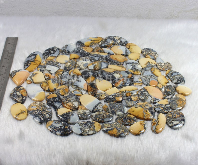 K&ouml;nnte beinhalten: Eine Sammlung von 50 nat&uuml;rlichen, polierten, ovalen Landschaftsjaspis-Cabochons. Die Steine sind eine Mischung aus Braun, Wei&szlig; und Schwarz mit einer Vielzahl von Mustern.