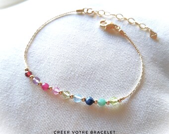 May include: A gold chain bracelet featuring a selection of colourful gemstones. The bracelet has a clasp fastening and is decorated with a small charm. The text "CREER VOTRE BRACELET By Paradisso Julia" is printed below the bracelet.