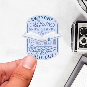 May include: A blue and white sticker with the text "Awesome Dads Grow Beards & Are Well Read In Scripture & Theology". The sticker features an open book with a blue bookmark.