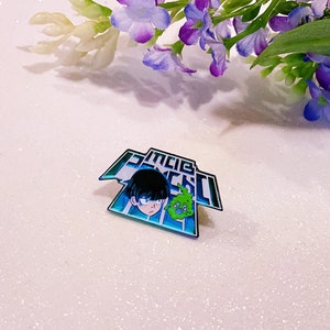 Puede incluir: Un pin de esmalte verde azulado y plateado con un personaje de la serie de anime Mob Psycho 100. El pin representa a un personaje con cabello negro y un espíritu verde. El pin está sobre una superficie blanca y brillante.