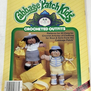 May include: A softcover pattern book titled Xavier Roberts Presents Cabbage Patch Kids Crocheted Outfits #7867 Plaid. The yellow cover features two dolls wearing crocheted clothing, with text detailing patterns for 20 easy-to-crochet articles of clothing.