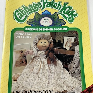 May include: A yellow Cabbage Patch Kids pattern booklet titled Xavier Roberts Presents Preemie Designer Clothes #7809 Plaid. The cover features a doll in a floral dress and bonnet holding a brown teddy bear, with text stating Make Over 20 Outfits.