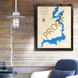 May include: A framed wooden map of Conchas Reservoir in New Mexico, with blue water features and the text "PROOF" diagonally across the image. The map includes the reservoir's name, county, and a compass rose.