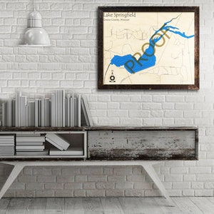 May include: A wooden map of Lake Springfield in Greene County, Missouri. The map is framed in a dark brown frame and has a blue lake with depth contours.