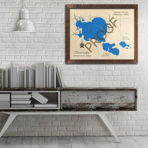 May include: A framed map of Oliver Lake in LaGrange County, Indiana. The map shows the lake's depth contours in blue, with a compass rose and the lake's area and deepest point measurements.