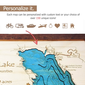 May include: A wooden map of a lake with depth contours marked in blue. The map is framed in brown wood and includes the names of nearby towns and landmarks, such as Kalispell Bay, Bigfork, and Wayfarers State Park.