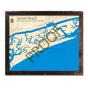 May include: A nautical chart map of Sunset Beach, Brunswick County, North Carolina. The map shows the coastline, waterways, and surrounding islands. The map is printed on a cream-colored background with blue water and brown land features.