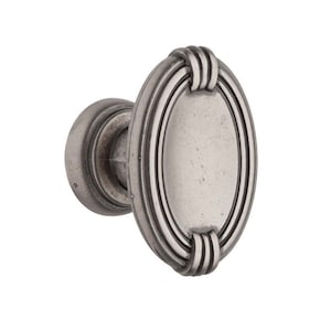 May include: A silver-toned oval cabinet knob with a decorative rope design around the edge.