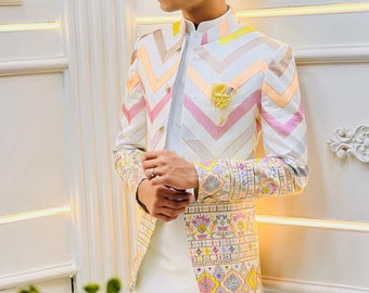 Könnte beinhalten: Ein weißer Blazer mit einem Chevron-Muster in Rosa, Orange und Gelb. Der Blazer hat einen Stehkragen und einen Blumendruck auf dem Ärmel.
