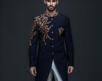 May include: A navy blue long-sleeved jacket with gold embroidery and a gold button closure. The jacket has a mandarin collar and is worn over white pants.