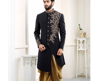 Puede incluir: Una kurta negra de manga larga con bordados dorados y un dhoti dorado a juego. La kurta tiene un cuello alto y cierre de botones.