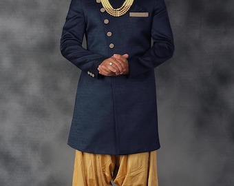 Könnte beinhalten: Eine marineblaue, langärmelige Kurta mit goldenen Knöpfen und einer goldenen Perlenkette. Die Kurta wird mit einer goldfarbenen Hose getragen.