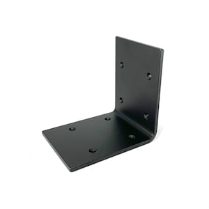 Könnte beinhalten: Ein schwarzer Winkel aus Metall. Er hat eine flache Basis und eine vertikale Seite, beide mit vorgebohrten Löchern zur Befestigung. Die Ecke ist abgerundet. Dieser Winkel ist für die strukturelle Unterstützung konzipiert.