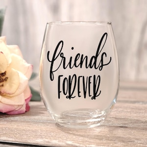 May include: A clear glass wine glass with the text "Friends Forever" written in black calligraphy.