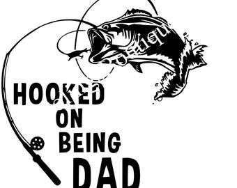 May include: Black and white illustration of a fish jumping out of the water with a fishing rod and the text "HOOKED ON BEING DAD".