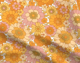 May include: A fabric textile featuring a dense, repeating floral pattern with various sizes of flowers in shades of mustard yellow, burnt orange, soft pink, and cream. The design covers the entire surface with overlapping petals and leaves.