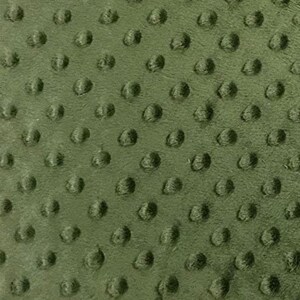 May include: Close-up of olive green fabric with a raised, textured pattern of evenly spaced, rounded bumps. The fabric has a soft, plush appearance, and the texture creates a tactile, three-dimensional effect. The color is a muted, earthy green.