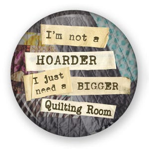 May include: A round button with a patchwork fabric background. The button has text that reads "I'm not a hoarder I just need a bigger quilting room".