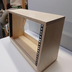 May include: A wooden rack for audio equipment, with a light wood finish and black metal rails. The rack is empty and ready to be filled with gear.