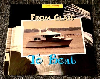 May include: A book cover with the title "From Glass To Boat" in large, bold, blue letters. The cover features a photo of a white boat on the water.