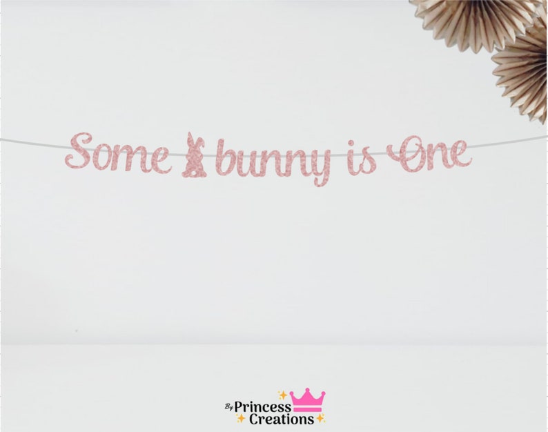May include: Pink glitter banner with the text "Some bunny is one" and a pink glitter bunny silhouette.