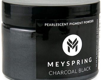 May include: A jar of charcoal black pearlescent pigment powder. The jar is labeled "Meyspring Charcoal Black" and features a logo with the letter "M" in a stylized font.