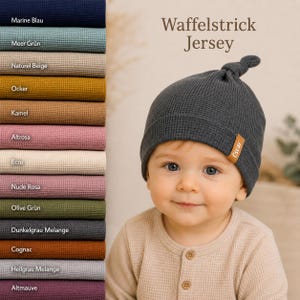 May include: A dark gray waffle knit beanie with a top knot and a small brown tag labeled Oscar. To the left, a vertical stack of fabric swatches in various colors including navy, teal, beige, ochre, camel, pink, ecru, mauve, olive, and gray.