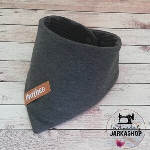 May include: Gray bandana bib with a brown leather label that says "matheo" and a snap closure. Handmade by Jarkashop.