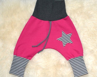 Puede incluir: Pantalones para niños de color rosa y gris con un diseño de estrella. Los pantalones tienen una cintura gris y puños a rayas.