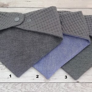 May include: Three reversible fabric squares with different patterns. The first square is gray with a waffle texture on one side and a gray and white patterned fabric on the other side. The second square is gray with a waffle texture on one side and a blue denim fabric on the other side. The third square is gray with a waffle texture on one side and a solid gray fabric on the other side.