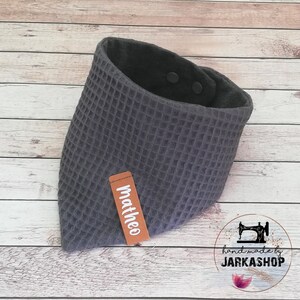 May include: Gray waffle weave bandana bib with a brown label that says "Mattheo" and two black snaps. The bib is handmade by Jarkashop.