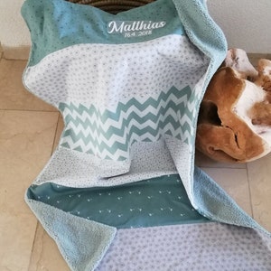 Könnte beinhalten: Eine weiche, blaue und weiße Babydecke mit einem Zickzackmuster und einem personalisierten Namen, "Matthias 16.4.2018", oben bestickt.
