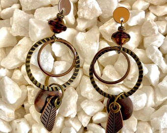 Rebirth Brass mixed metal, reimagining the classic hoop earrings. Accented with a dazzling Picasso bead in purple and bronze Czech glass.