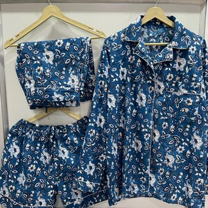 May include: A blue pajama set with a floral print. The set includes a long-sleeved shirt, shorts, and pants.
