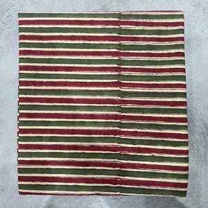 May include: Red and green striped fabric with a white background. The fabric is woven and has a subtle texture.