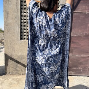 Puede incluir: Una kaft&aacute;n de estampado floral azul y blanco con cuello en V y un lazo en la cintura.