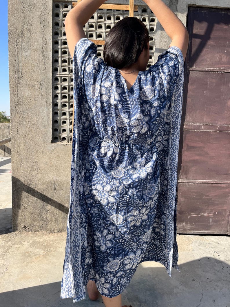 Puede incluir: Una kaft&aacute;n de estampado floral azul y blanco con cuello en V y un lazo en la cintura.