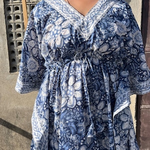 Puede incluir: Una kaft&aacute;n de estampado floral azul y blanco con cuello en V y cintura con cord&oacute;n.