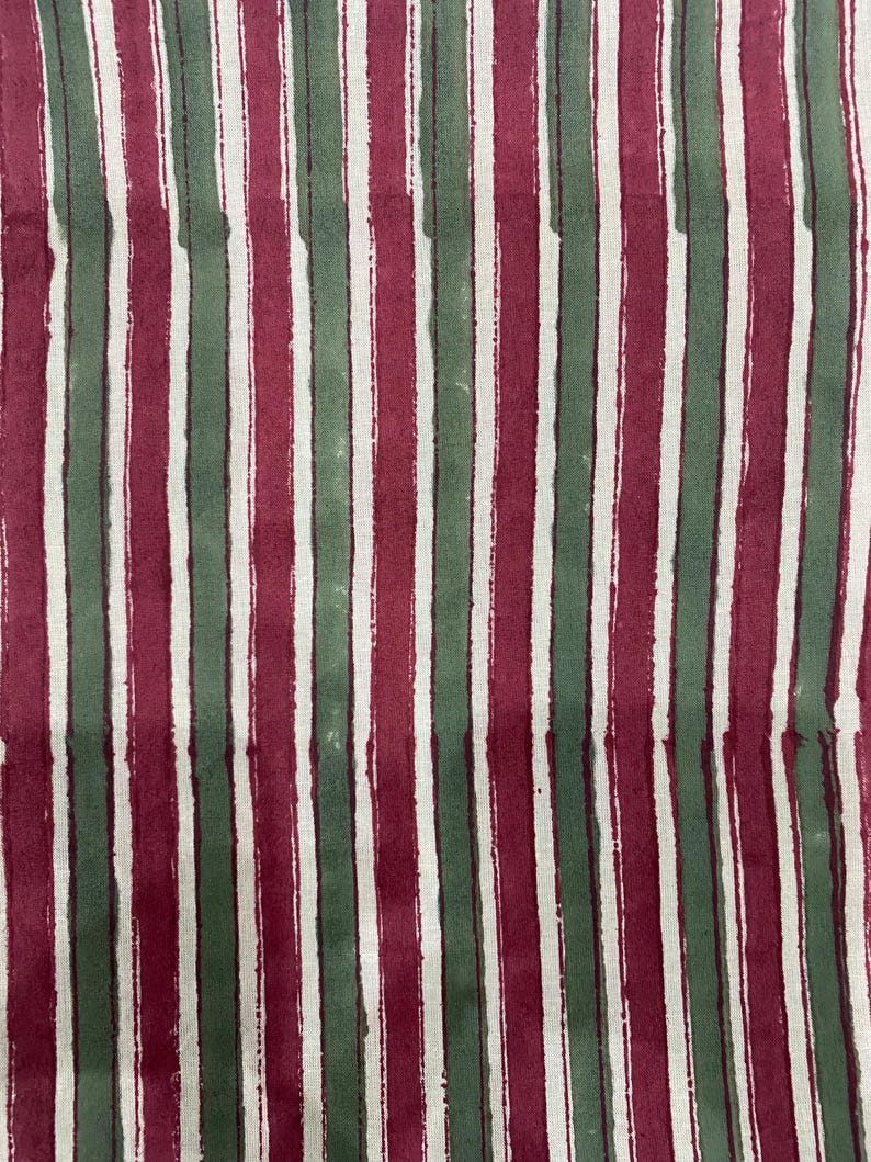 May include: Fabric with alternating vertical stripes of burgundy and dark green. The stripes are hand-painted and have a slightly uneven texture.