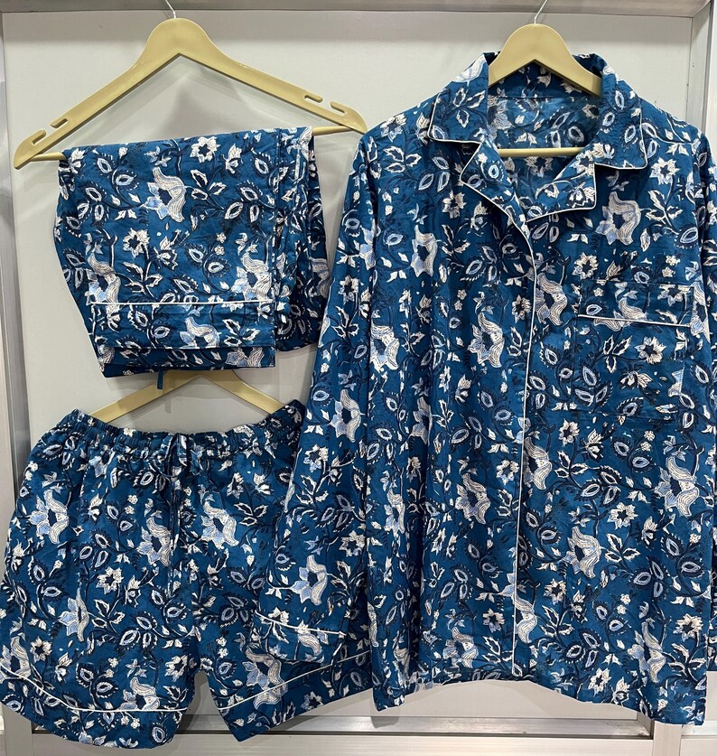 May include: A blue pajama set with a floral print. The set includes a long-sleeved shirt, shorts, and pants.