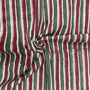 May include: Striped fabric with alternating red and green stripes. The fabric has a white background and the stripes are a darker shade of red and green.