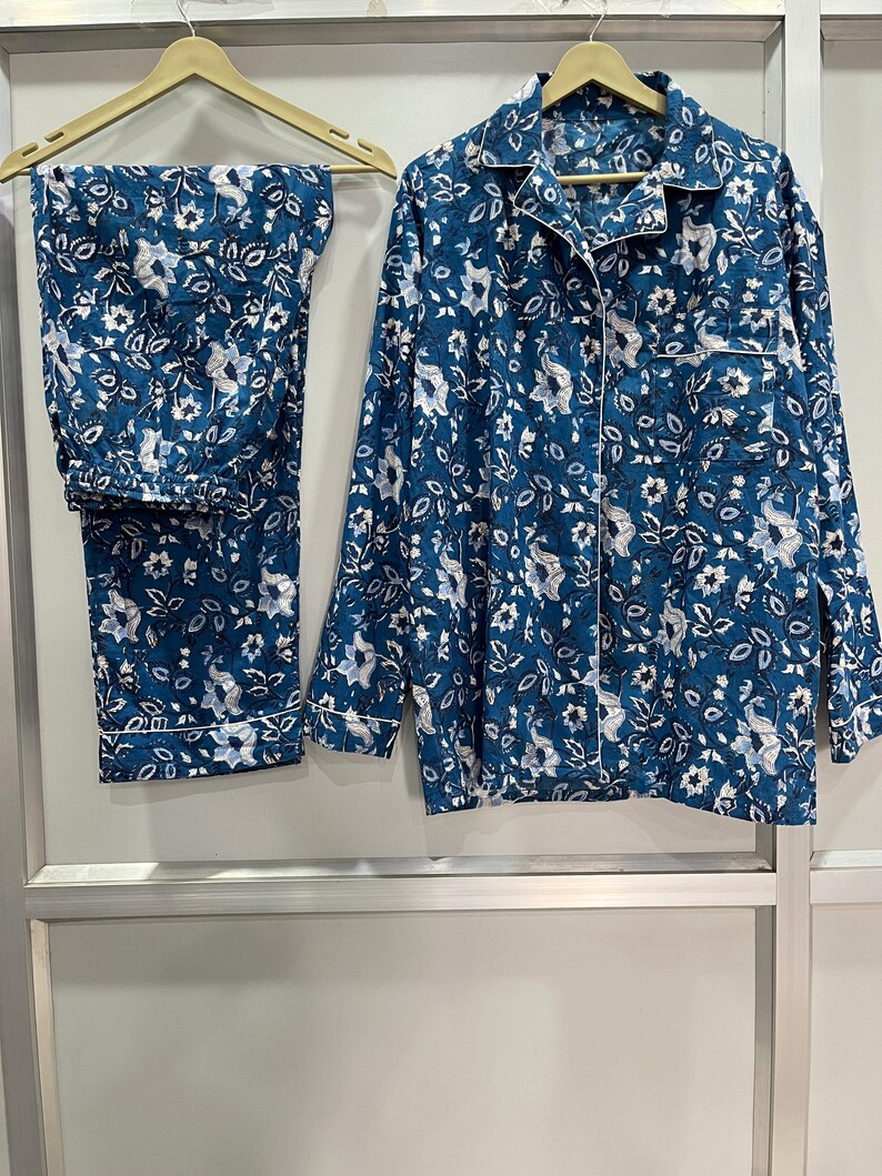 May include: A blue and white floral print pajama set with long sleeves and pants. The set has a button-up front and a collared neckline.