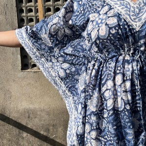 Puede incluir: Una kaft&aacute;n de estampado floral azul y blanco con cuello en V y cintura con cord&oacute;n.
