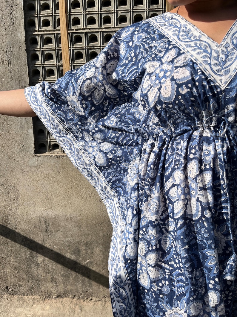 Puede incluir: Una kaft&aacute;n de estampado floral azul y blanco con cuello en V y cintura con cord&oacute;n.