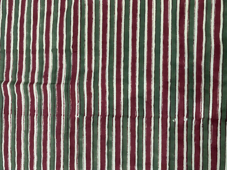 May include: A fabric with alternating stripes of burgundy, green, and white. The stripes are painted on the fabric, giving it a textured look.